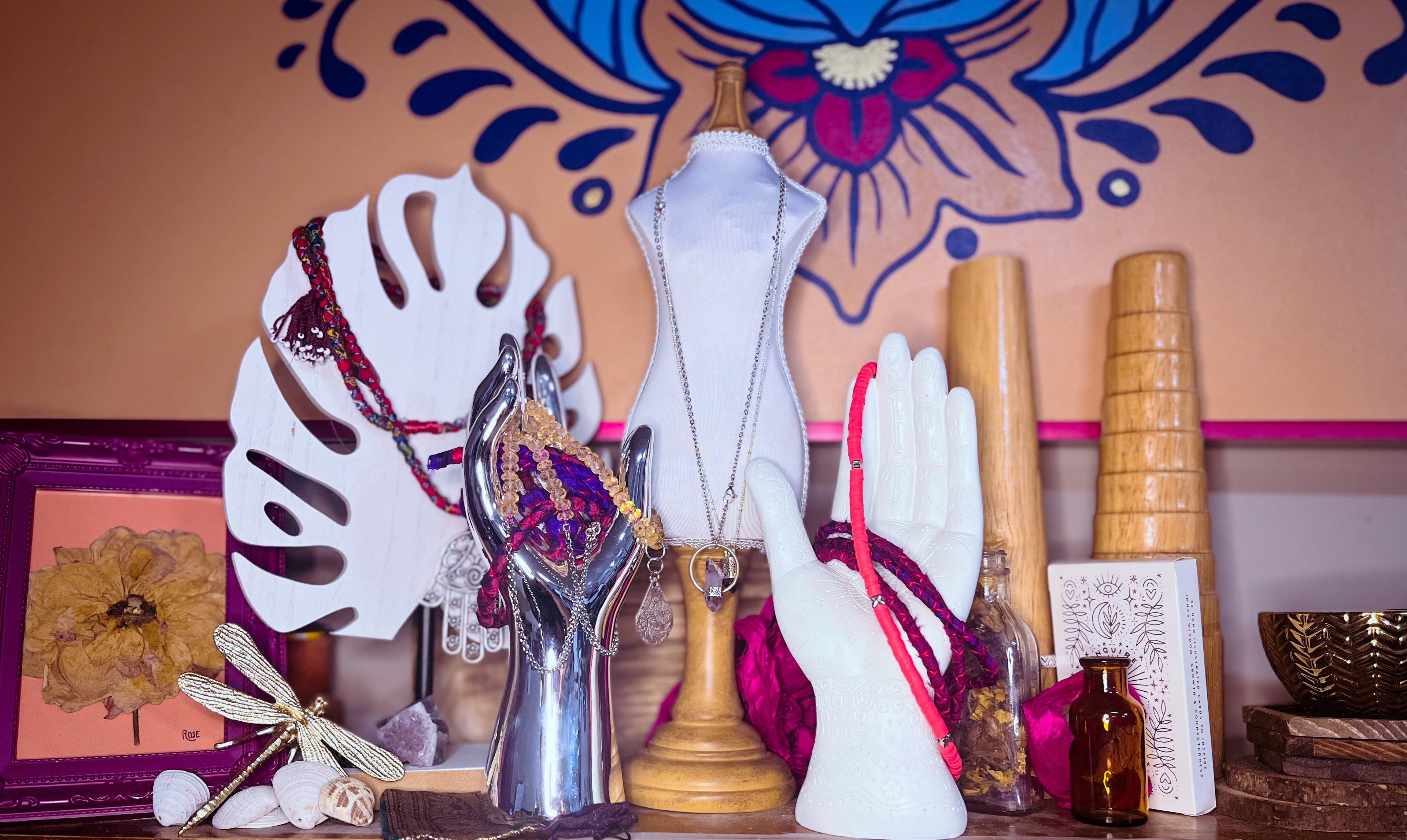 Decorative shelf with various items including a silver trophy, white gloves, and a colorful wall in the background.